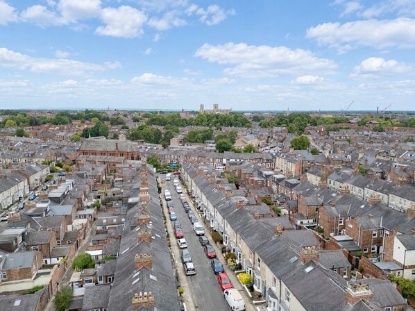 A residential area with terraced houses, a main road, and a distant church tower.