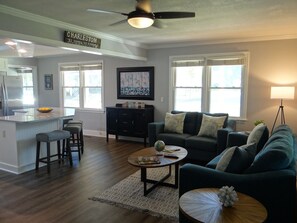 Relax in a stylish living space with a central island, comfortable seating area, and dining space.