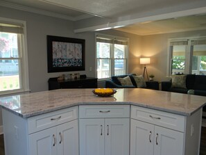 Enjoy a warm and inviting space with a large island, dining area, and a beautiful abstract painting.