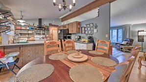 Un'ampia cucina con mobili in legno, un'isola centrale e un'area pranzo con tavolo e sedie in legno.