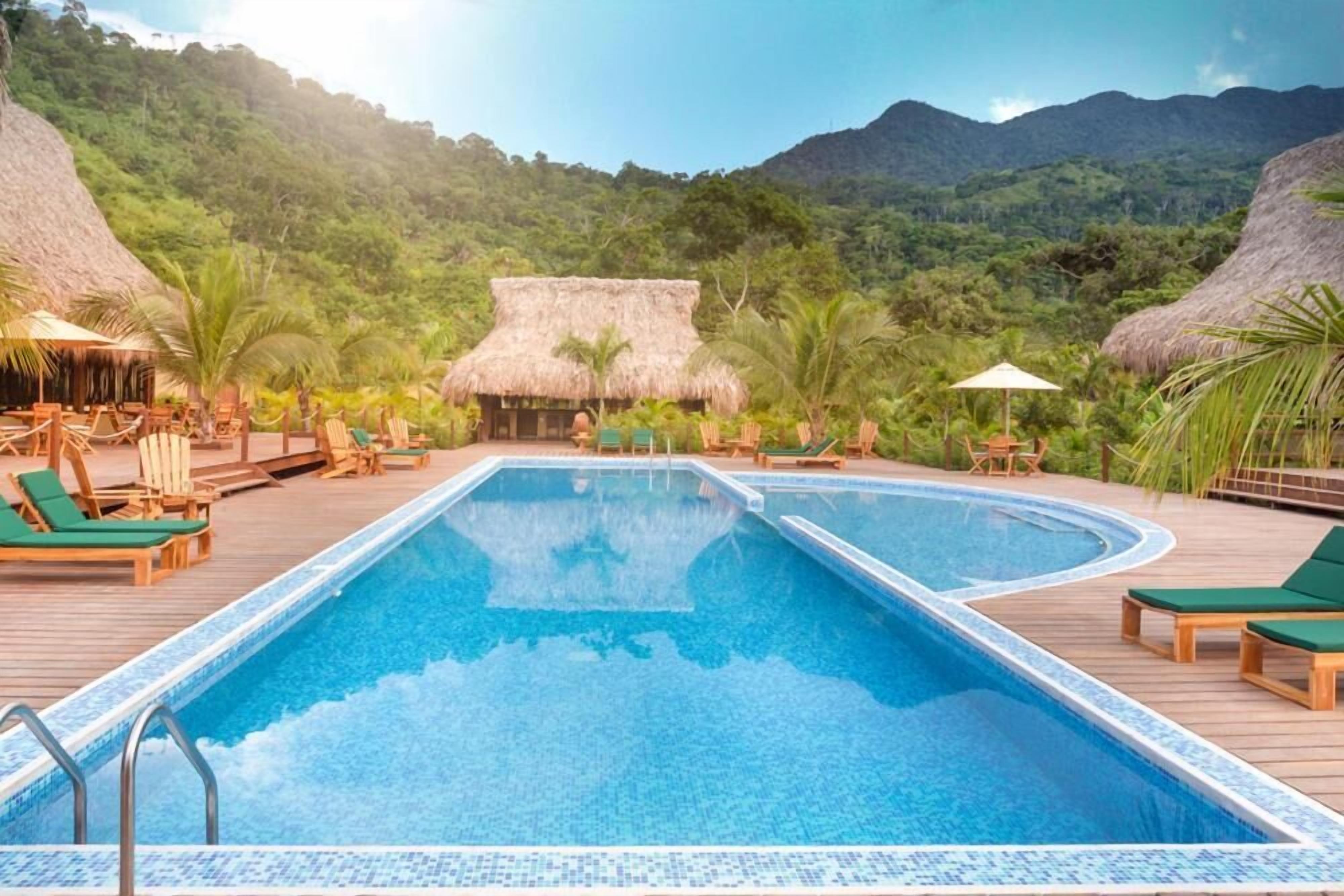 Una piscina al aire libre, sillones reclinables de piscina