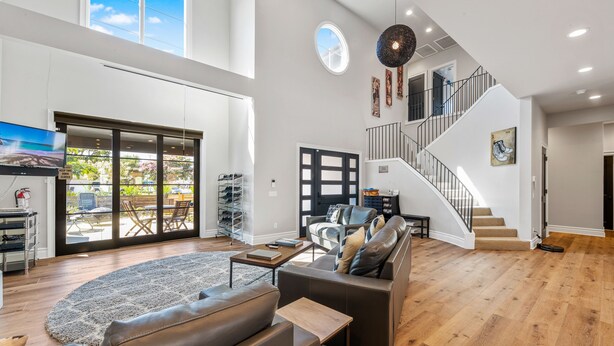 A spacious living area with a large sofa, a coffee table, and a staircase leading to an upper floor. - 4BR Resort Near Beach/Disney; Pool is +$149 /night (Huntington Beach)
