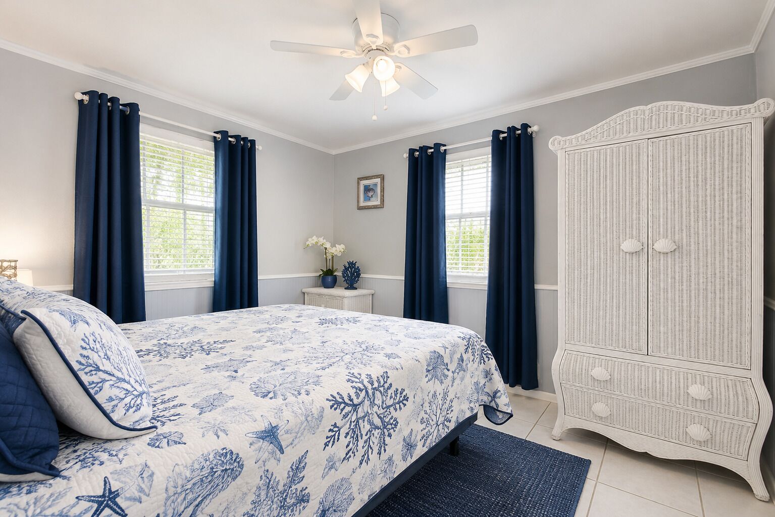 A bedroom with a bed, a nightstand, a dresser, and a ceiling fan.