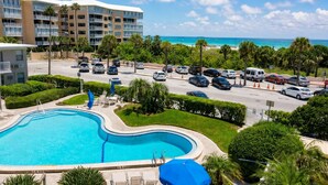 Ein Hotel mit Schwimmbad, Parkplatz und Blick auf den Ozean.