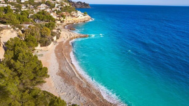 A coastal town with houses on a hillside overlooking a turquoise beach. - Vacation home Alexia by Interhome (Benissa)