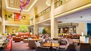 A spacious lobby with multiple seating areas, a decorative ceiling, and a second-floor balcony. - Yungang Jianguo Hotel (Datong)