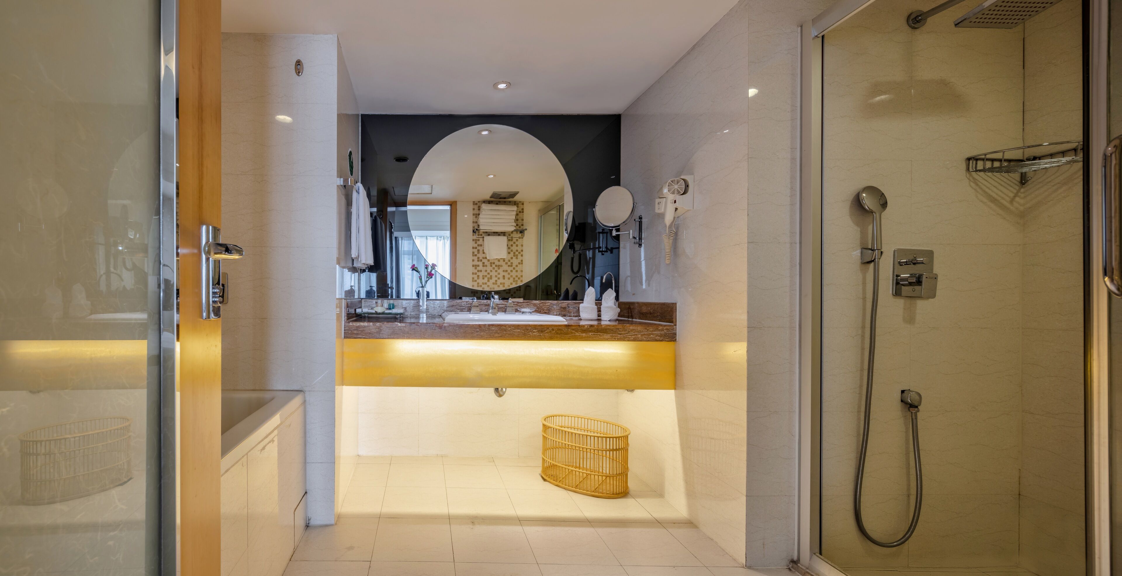 Une salle de bain moderne avec une douche à parois de verre, un meuble-lavabo avec un miroir et un porte-serviettes.