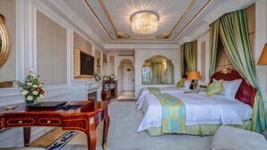 A luxurious hotel room with a large bed, a desk, and a chandelier. - Yungang Jianguo Hotel (Datong)