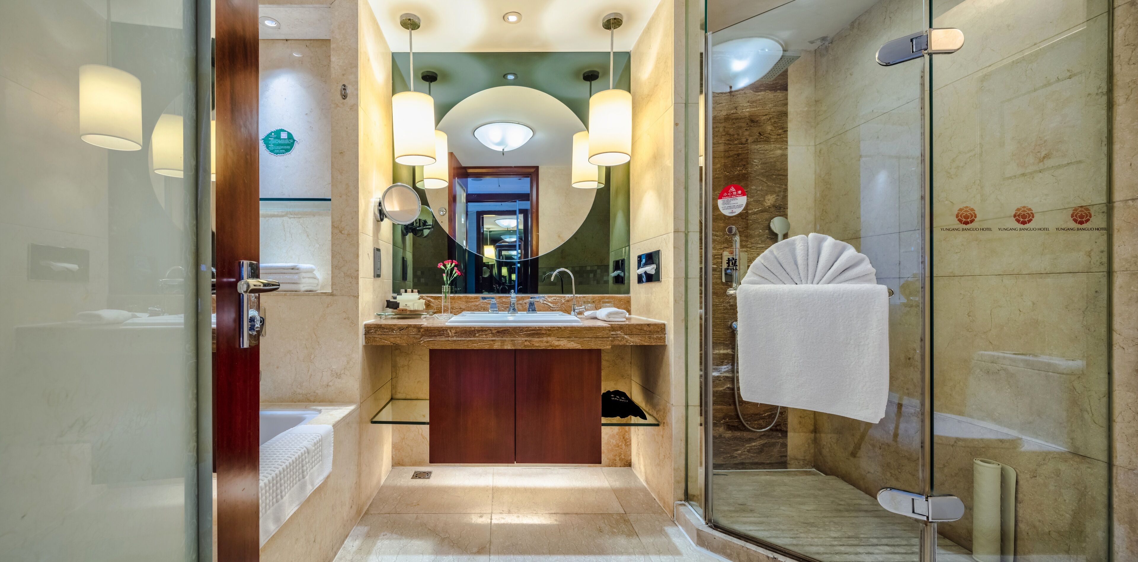 A modern bathroom with a glass-enclosed shower, a marble sink, and a vanity with a mirror.