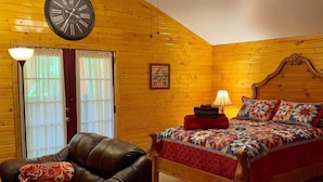A cozy room with a wooden ceiling, a bed with a quilt, a leather chair, and a wall clock. -  hot tub, grill, fireplace, Hocking Hills, Buckeye Lake, Legend Valley (Somerset)
