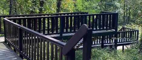 A wooden bridge with a metal railing in a park.