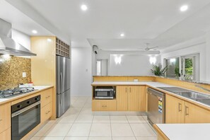 Fridge, cookware/dishes/utensils, dining tables - Official Lakes Resort Three Bedrooms Apartments (Cairns North)