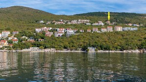 Un pueblo costero con edificios a lo largo de la costa y una colina al fondo.