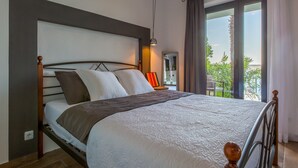 A modern bedroom with a large bed, a nightstand, a lamp, and a view of the outdoors. - Villa Fun Haus 2 (Jadranovo)