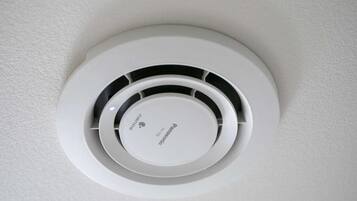 Et rundt ventilationsgitter med Panasonic-logo, der angiver et indbygget klimaanlæg.