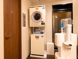Habitación de hotel con lavadora, secadora y dispensador de agua.