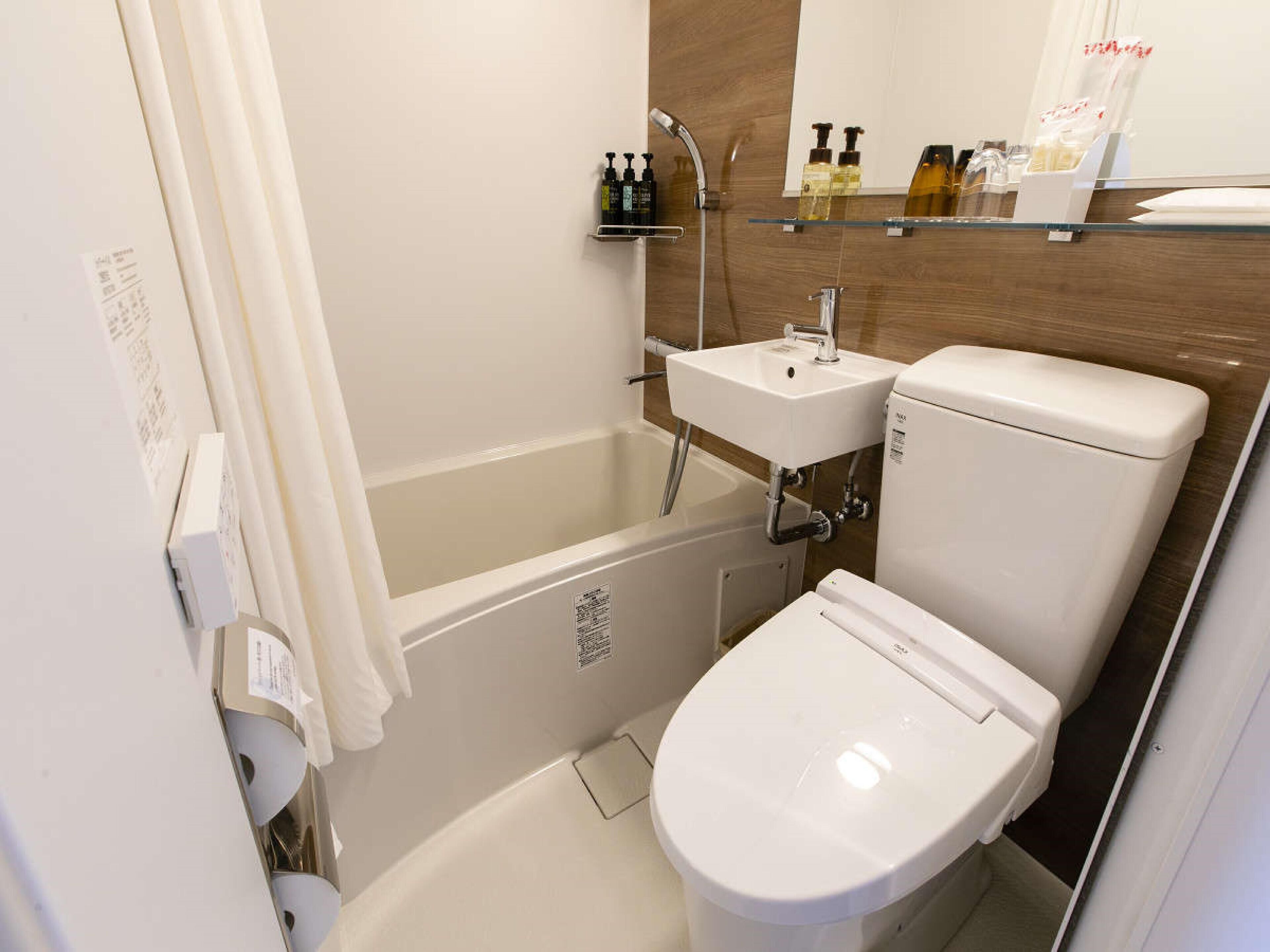 A bathroom with a bathtub, toilet, and sink.