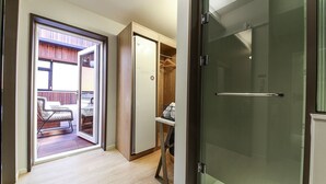 A hallway with a sliding glass door leading to a balcony with outdoor furniture. - Gijang No.25 Hotel (Busan)