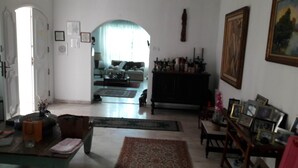 Una sala de estar con sofá, mesa de centro, alfombra y aparador con fotos enmarcadas.