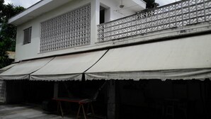 A two-story building with a covered outdoor area featuring a table and chairs.