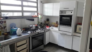 A compact kitchen with a gas stove, oven, and a microwave.