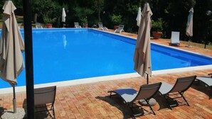 A swimming pool with lounge chairs and umbrellas, surrounded by trees. - Double Twin Room Private Bathroom for Swimming Pool use (Treia)