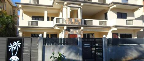 A multi-story residential building with balconies, a gated entrance, and a sign indicating 'RESIDENCE LA COLOMBE'.