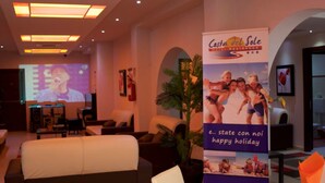 A hotel lobby with a reception desk, seating area, and a large poster advertising 'Costa del Sole Hotel Residence'. - Costa del Sole Apartment 50 Meters From the Beach of the Catania Coast (Catania)