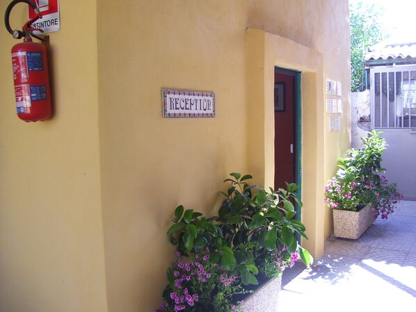 A reception area with a sign, a fire extinguisher, and potted plants. - Costa del Sole Apartment 50 Meters From the Beach of the Catania Coast (Catania)