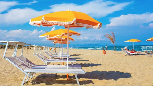 A beach with rows of sun loungers and orange umbrellas. - Costa del Sole Apartment 50 Meters From the Beach of the Catania Coast (Catania)