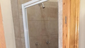 A shower with a glass door, tiled walls, and a wooden frame. - Karl Heyne Guesthouse - Spacious Double Room (Rustenburg)