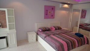 A bedroom with a bed, a nightstand, a dresser, and a mirror. - Jomtien Beach Condominium 3rd Floor apt (Pattaya)
