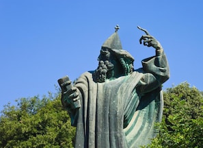 A statue of a robed figure with a pointed hat, holding a book and gesturing with the other hand. - Kind Room -hotel Rose Split (Split)