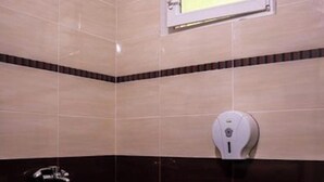 A bathroom with a toilet, sink, and a window above the sink. - Bungalow in a Lovely Village Kamena (Petrich)