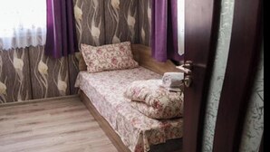 A bedroom with a bed, curtains, and a patterned wall. - Bungalow in a Lovely Village Kamena (Petrich)