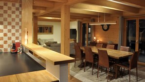Eine moderne Küche mit Holzarbeitsplatte und einem Essbereich mit großem Holztisch und Stühlen.