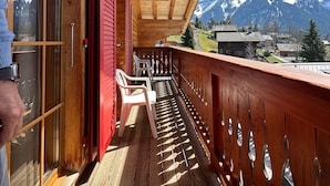 Ein Holzbalkon mit Blick auf schneebedeckte Berge.