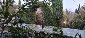 A table set outdoors with a tablecloth, two wine glasses, and a bottle. - Tuscan Villa, Private Pool and Tennis Court Garden,wi-fi, Ac, Pet Friendly (Rosignano Marittimo)