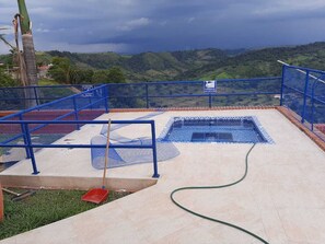 A swimming pool with a blue border and a view of green hills in the background. - Country House in Cerritos, Pereira (Pereira)