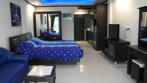 A modern bedroom with a bed, a desk, and a ceiling fan. - Baan Suan Lalana Td Floor 2 Room 203 (Pattaya)