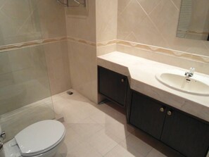 A bathroom with a toilet, a sink, and a mirror.