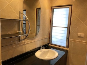 Ein Badezimmer mit Waschbecken, Spiegel und Fenster.