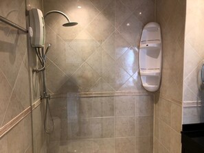 A bathroom with a shower, toilet, and a towel rack. - Baan Suan Lalana Te Floor 5 Room (Pattaya)