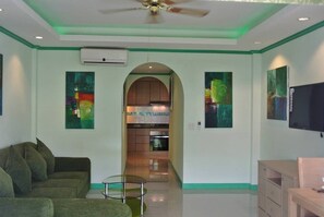 A living room with a sofa, a TV, and artwork on the walls.