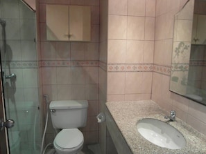 A bathroom with a toilet, sink, and shower.