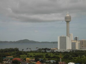 A coastal cityscape with a prominent tower and several high-rise buildings.