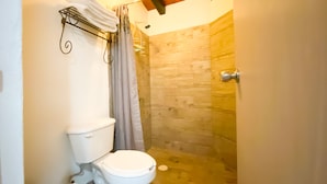 Un baño con inodoro, ducha y toallero.