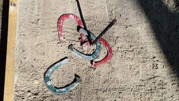 A wooden frame with a metal object inside, possibly a tool or part of a mechanism, on a sandy surface.