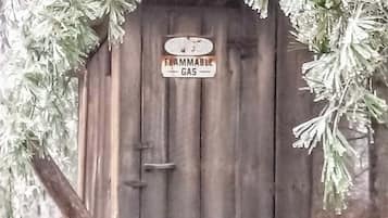 Un abri en bois sur lequel est affiché un panneau indiquant : « Gaz inflammable ».