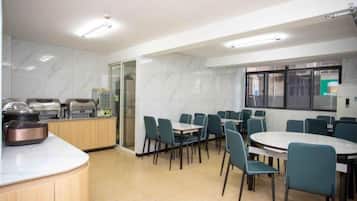 A modern dining area with a kitchen counter, seating arrangement, and a large window.